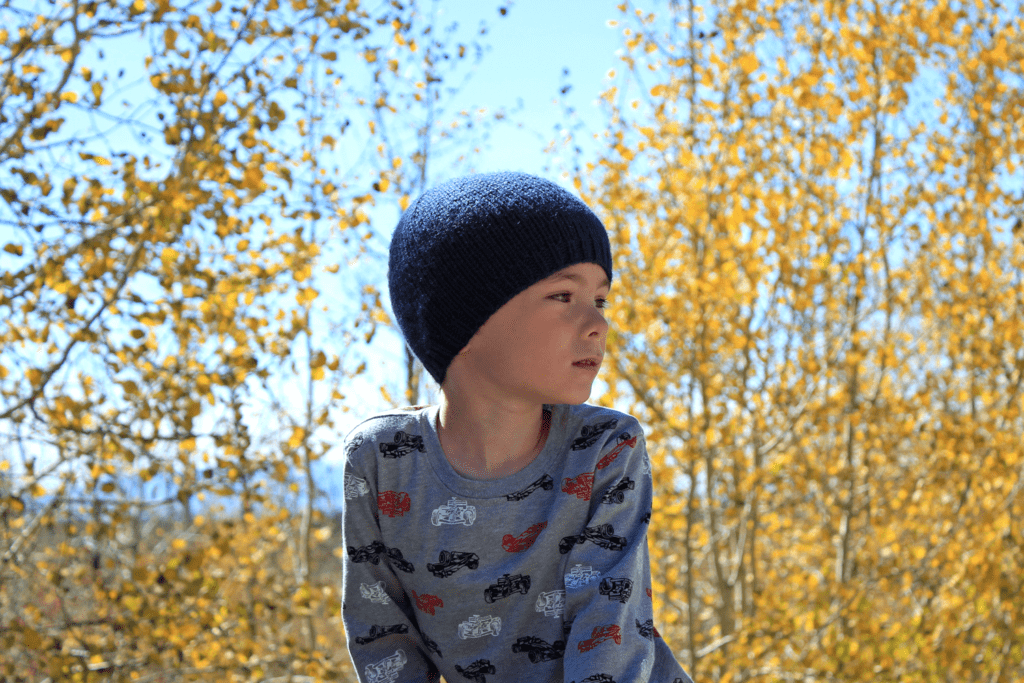 Boy in unisex simple knit beanie, hat knitting pattern in all sizes by Liz @PurlsAndPixels