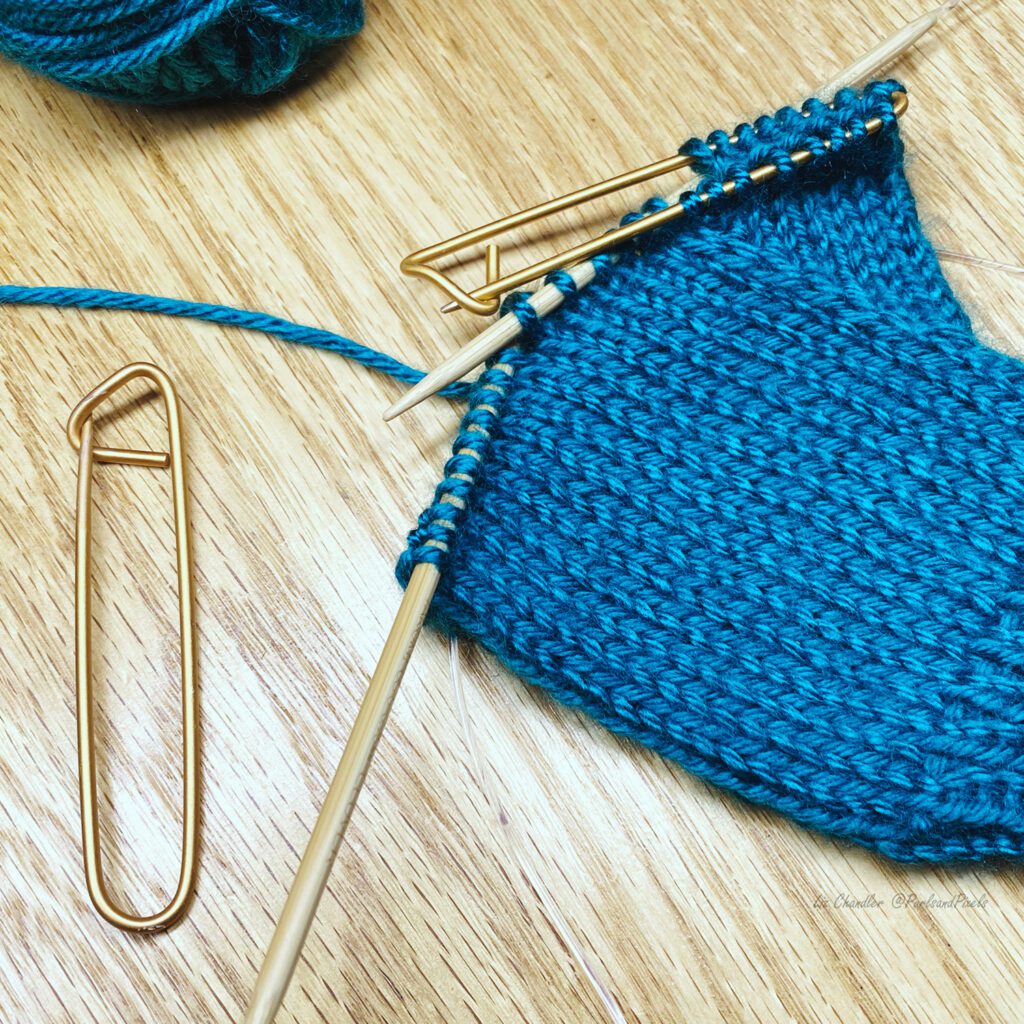Stitch holders take stitches off your knitting needles and save them for later knitting. Learn about stitch holders in this knitting lesson with Liz Chandler @PurlsAndPixels.