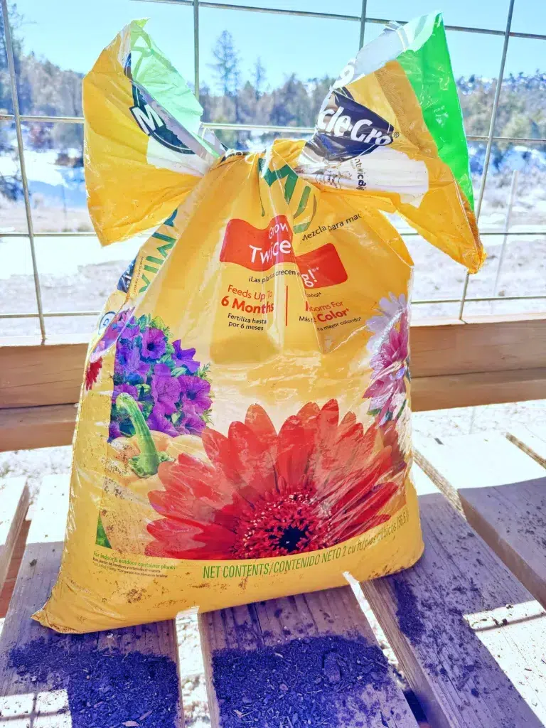 Open your potting soil with a vertical silt so you'll be able to close it more easily when you are done. Tie a cute little bow and no more soil spills!