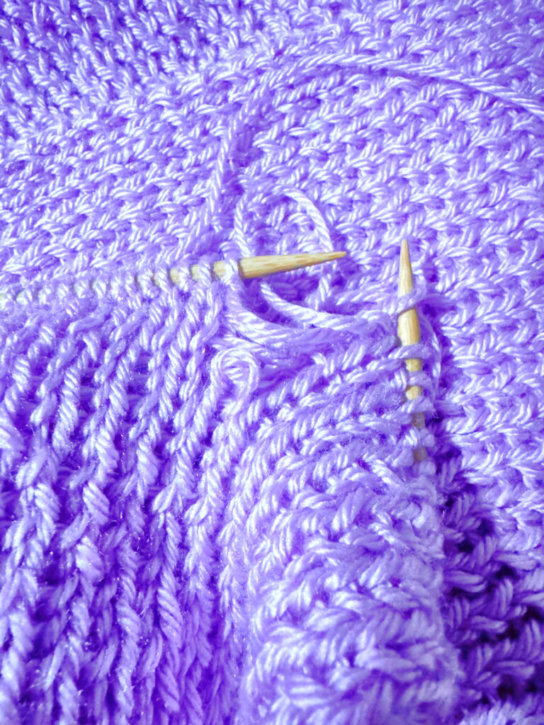 Knitted scarf with a dropped stitch that let a column of knitting drop - a mistake that can be fixed.