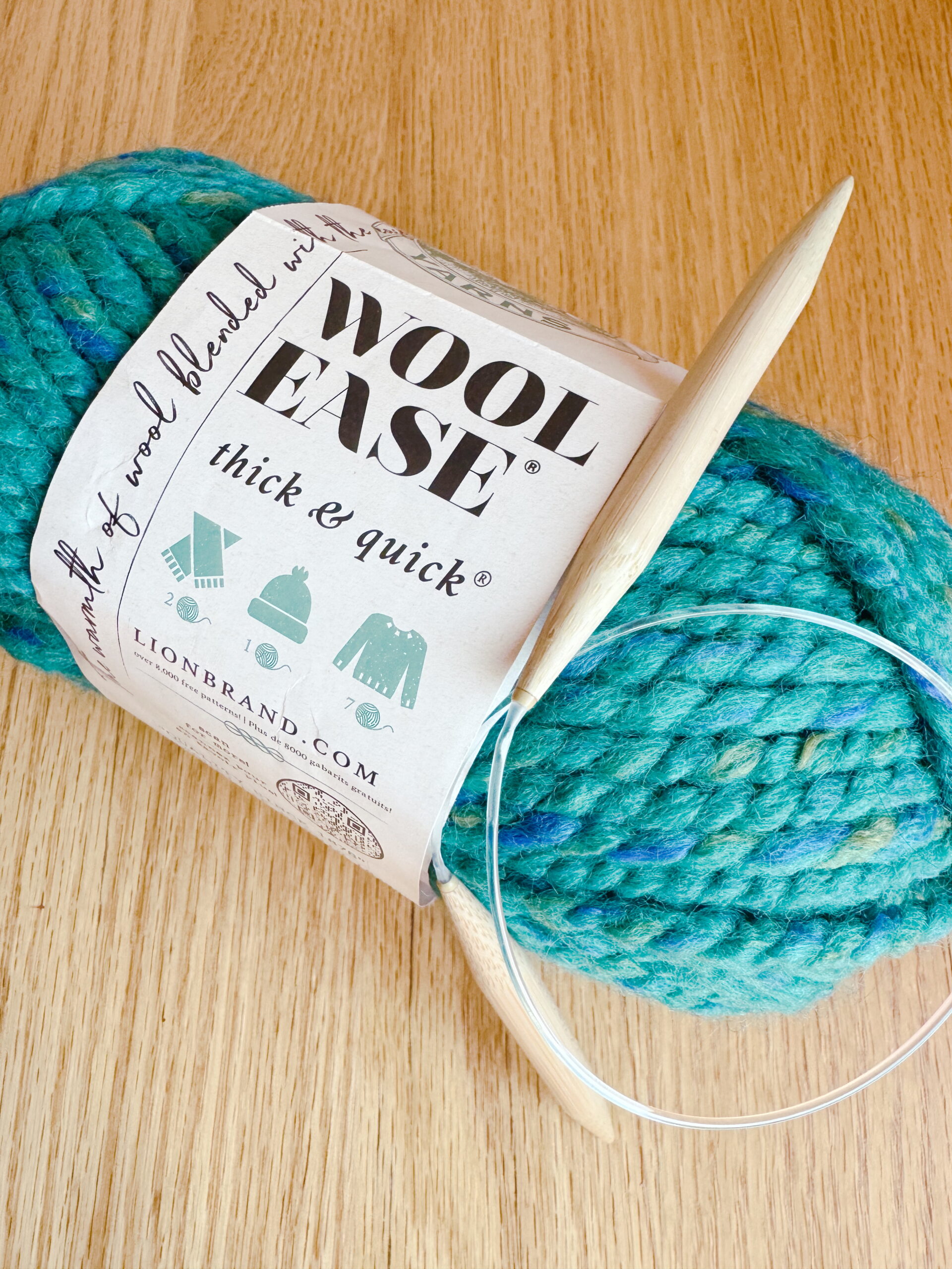 Kids' knitting lessons start with super-bulky yarn and US No. 13 needles, shown here on a wood-grain table.