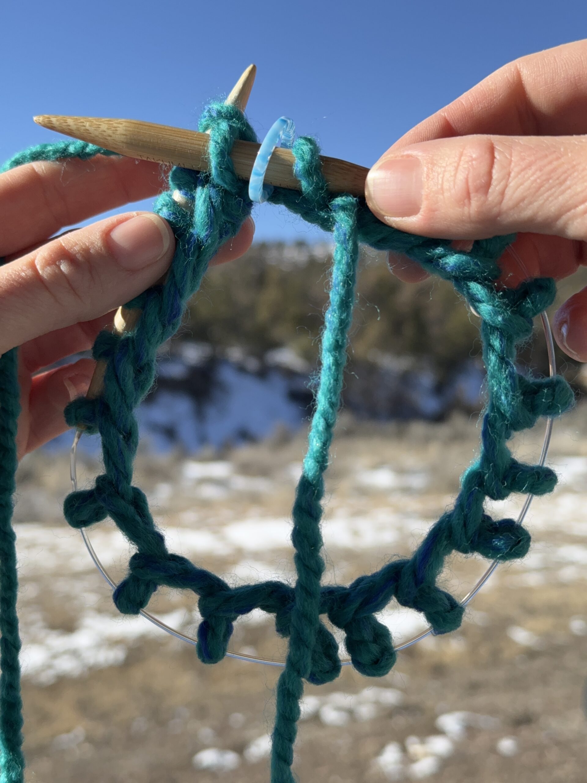 Lesson 8, Kids' Knitting Guide – circular knitting needles and yarn forming a tube of knitted fabric while knitting in the round.