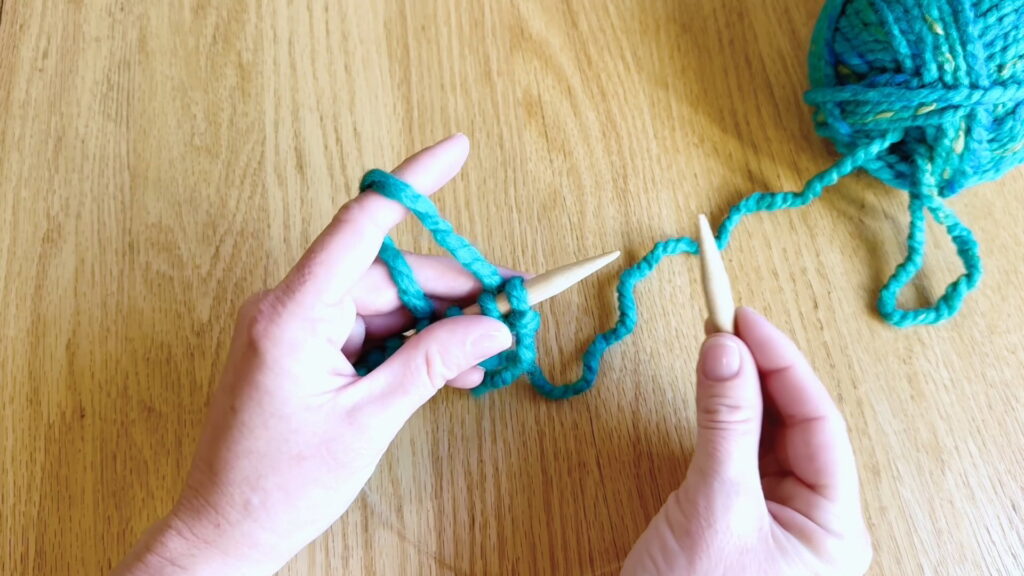 Knitting held in the left hand while the working yarn is draped over the pointer finger and the empty needle is held in the right hand.