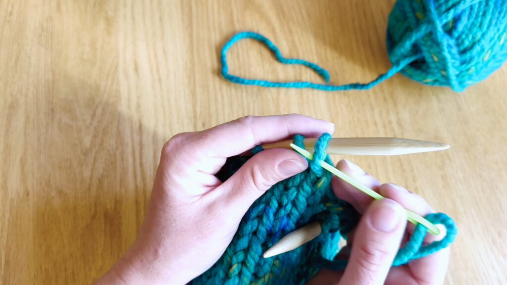 Lesson 9, Kids' Knitting Guide – sliding a stitch off the knitting needle onto a darning needle.