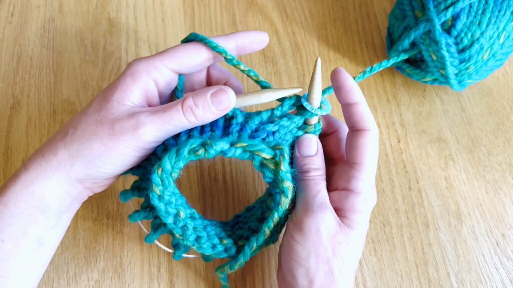 Lesson 8, Kids' Knitting Guide – continuing to knit around the circular needle to form a tube of knitted fabric.