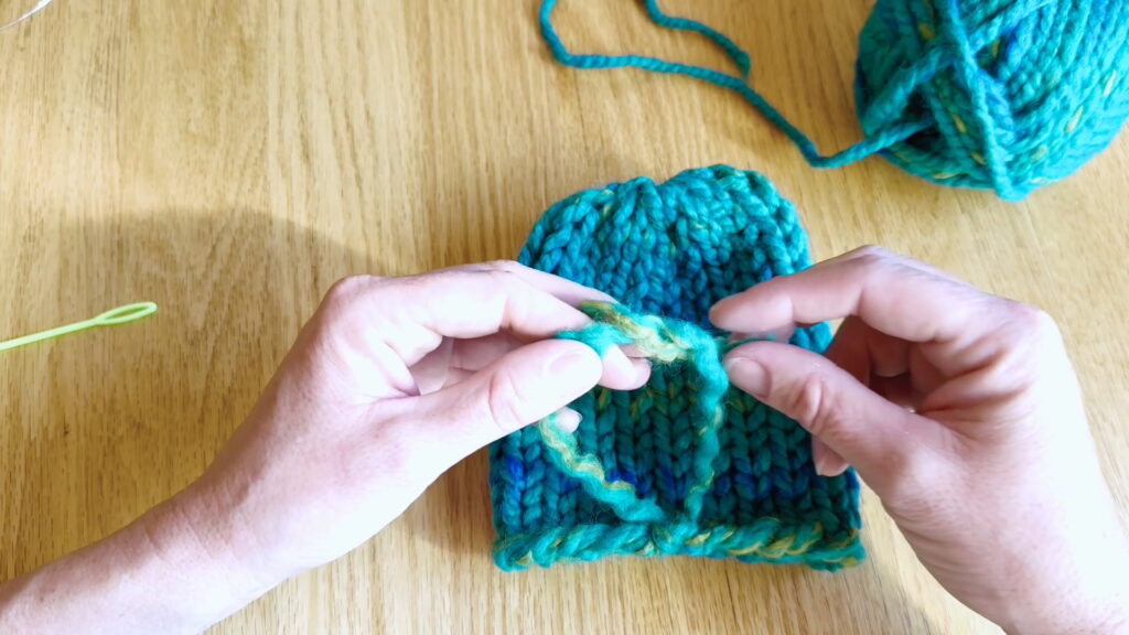 Lesson 10, Kids' Knitting Guide – tying a second knot to lock the yarn tail in place.